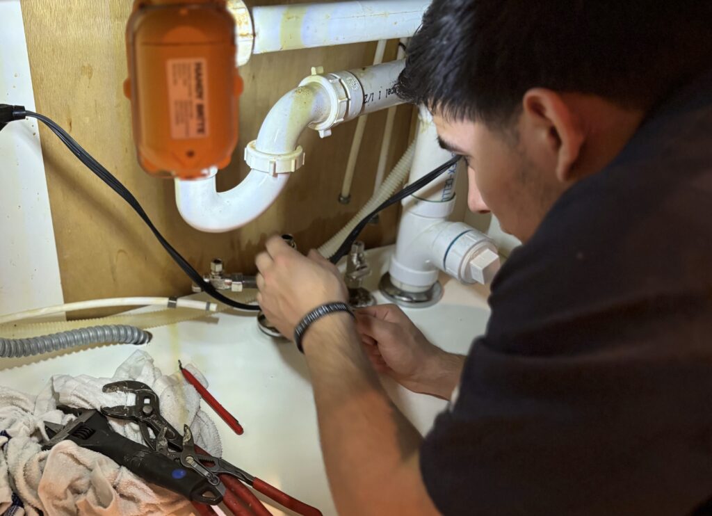A worker is checking the sink drain issues