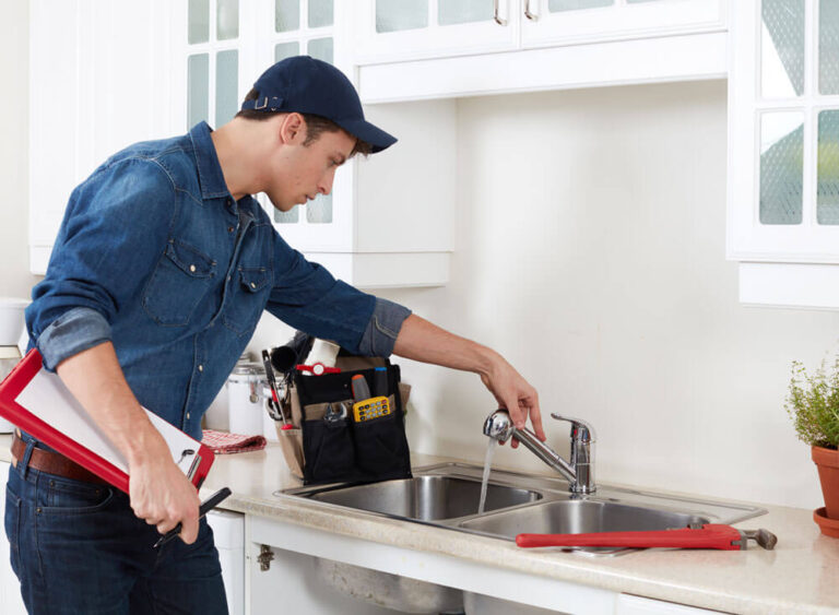 A plumber wearing cap, is checking the water faucet